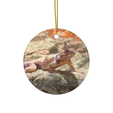 Front view of Val Weston's Gila Lagarto artwork on a round ceramic ornament hanging by a gold string